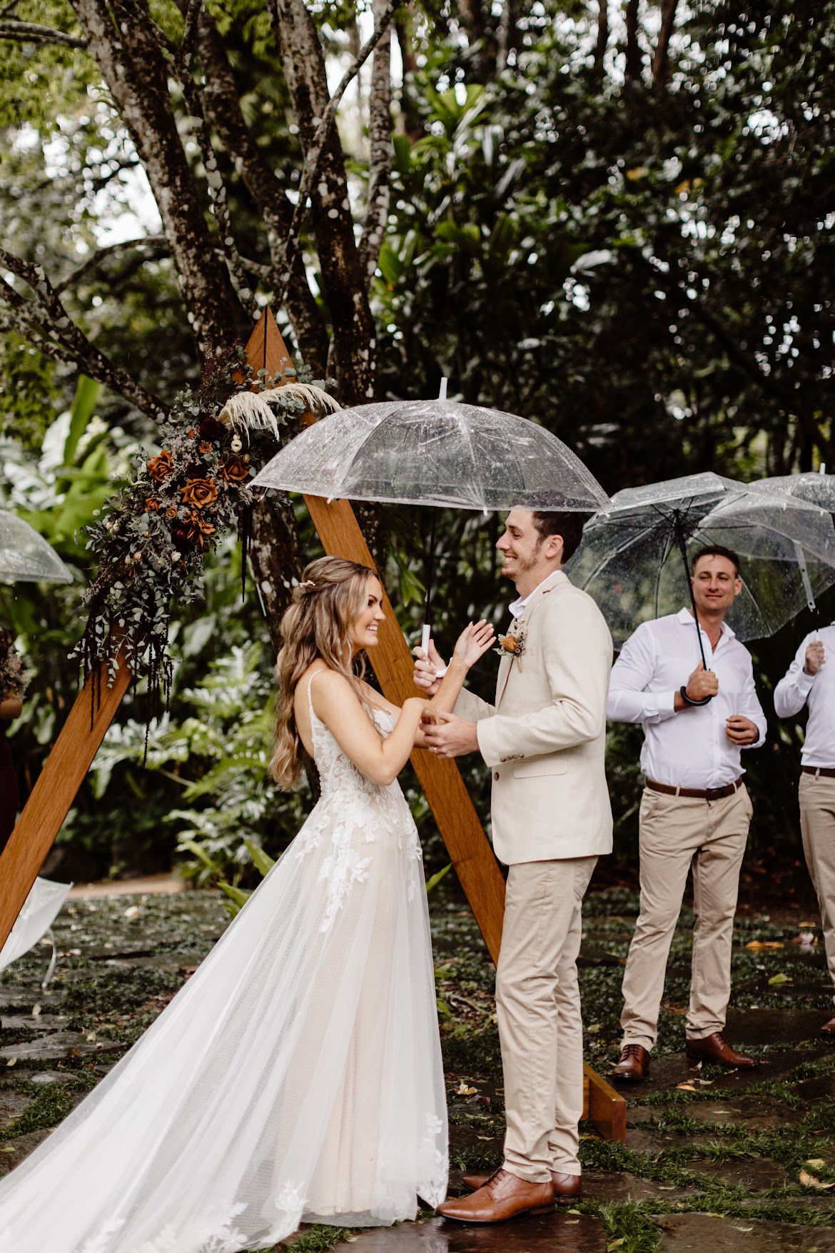 Bride and groom standing with triangle boho arbour